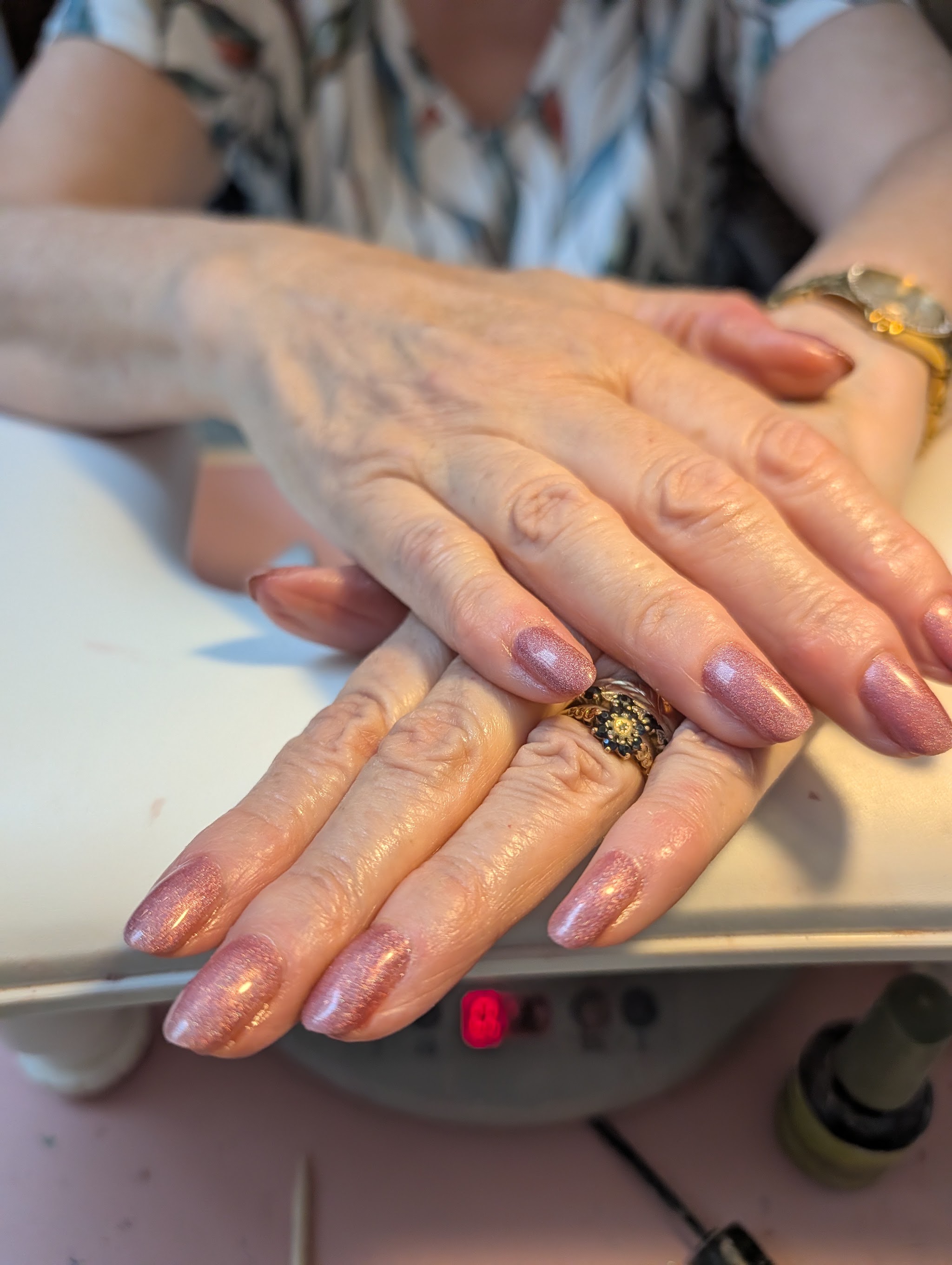 Shimmering rose gold almond nails at the nail station