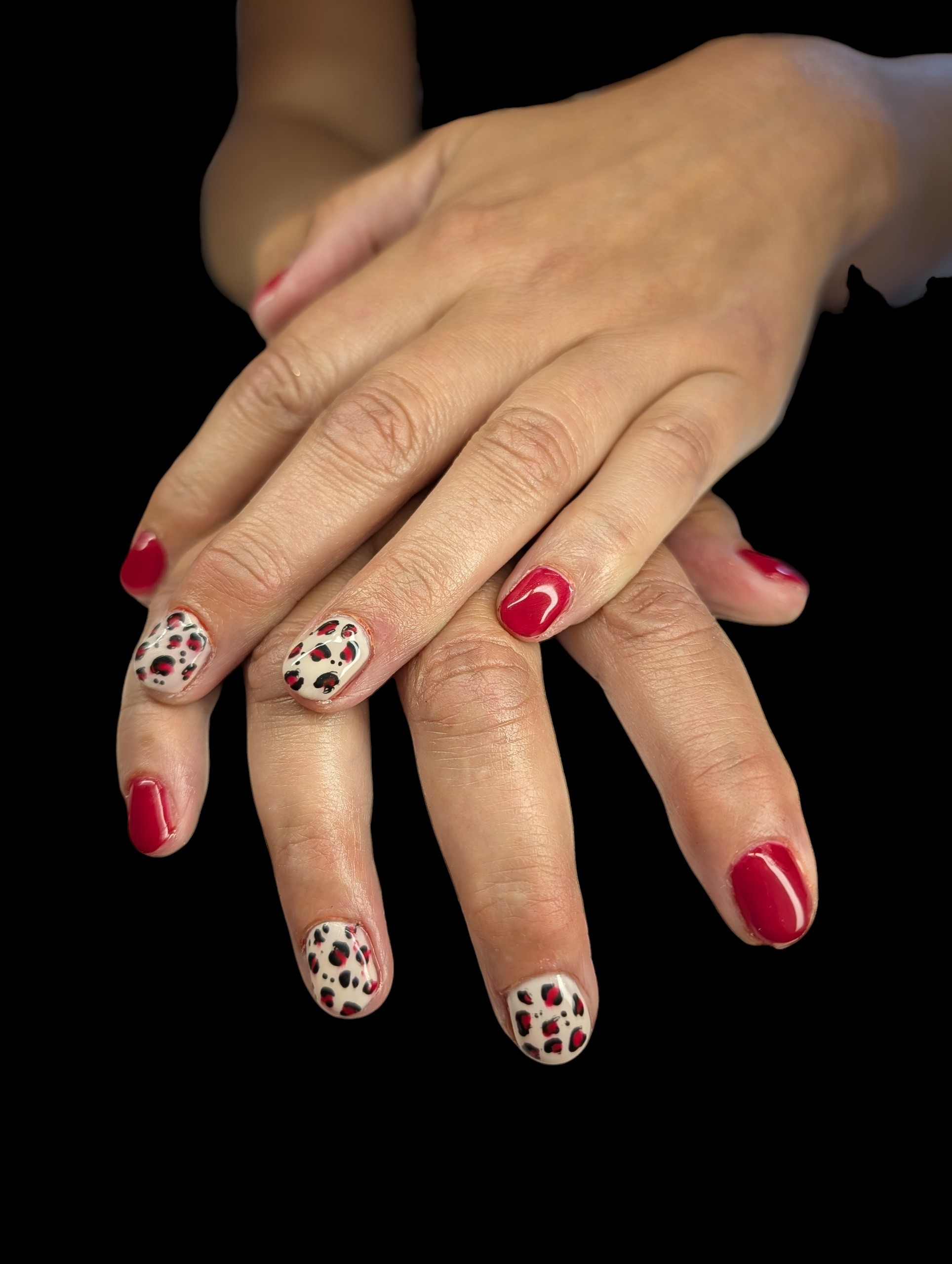 Red gel nails with leopard print nail art on two fingers