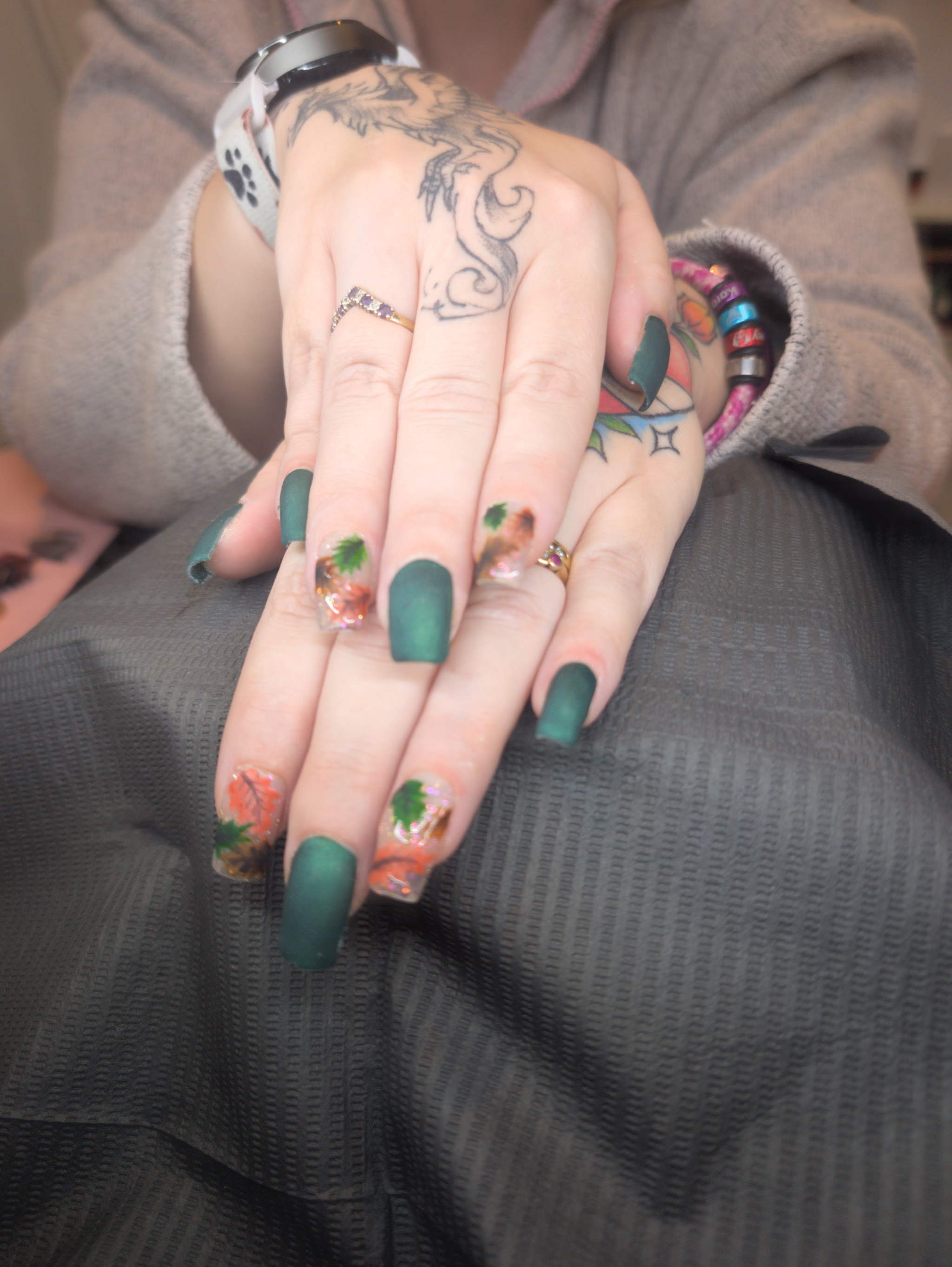 Matte forest green nails with hand-painted autumn leaves