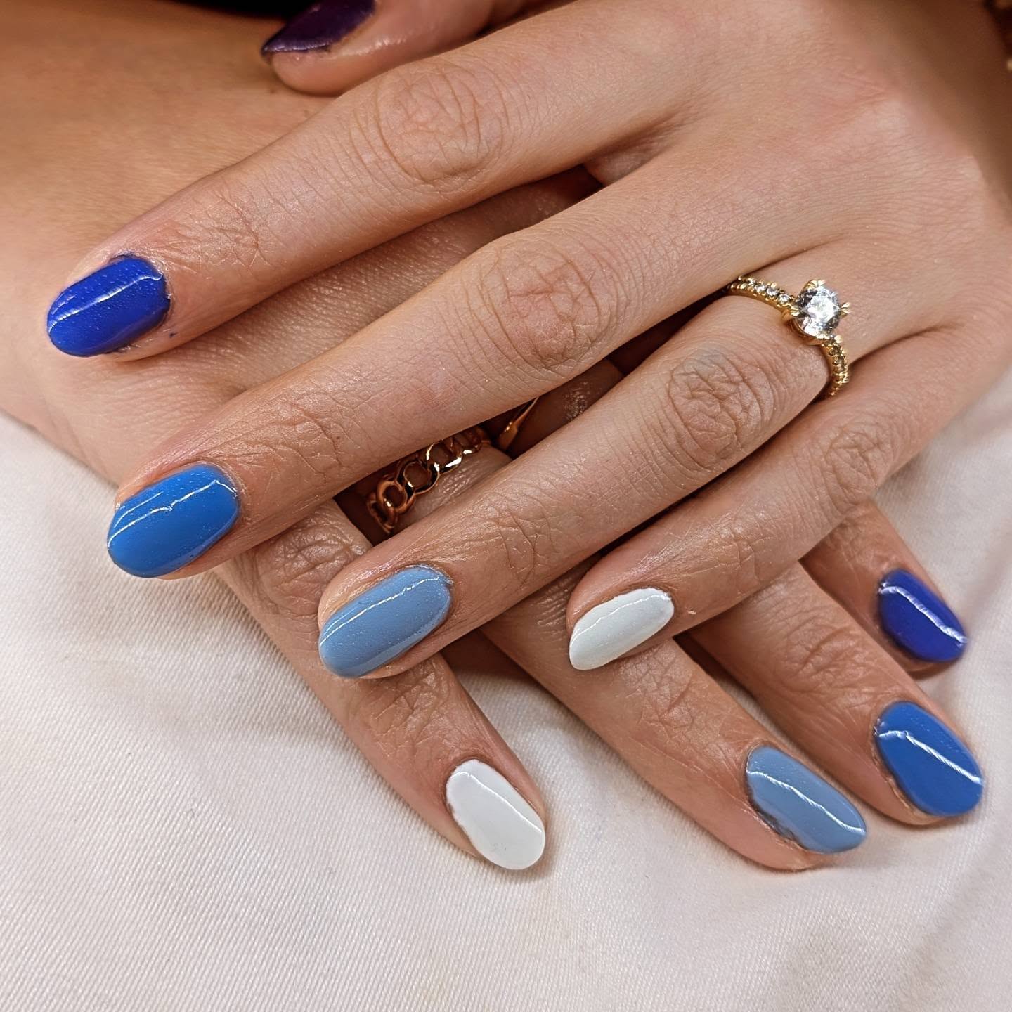 Gel manicure in shades of blue, from navy to pale sky